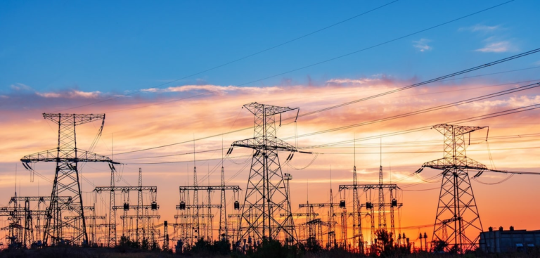 Power lines against a sunset outside a major power utility substation